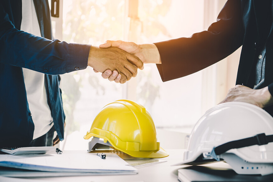 Shaking hands, hard hats and contracts