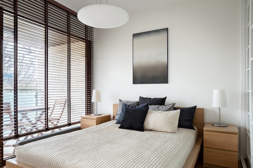 Small bedroom with large double bed and dark wood venetian blinds