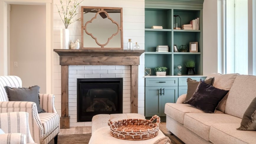 Living room with fireplace and wooden fire surround and mantelpiece. Decrative mirror placed above fireplace